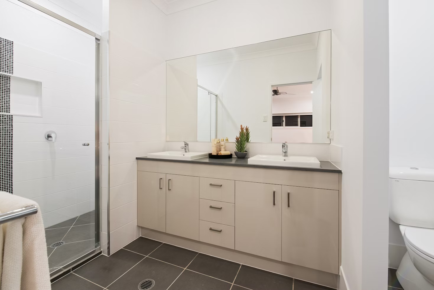 white bathroom door next to two sinks with storage space