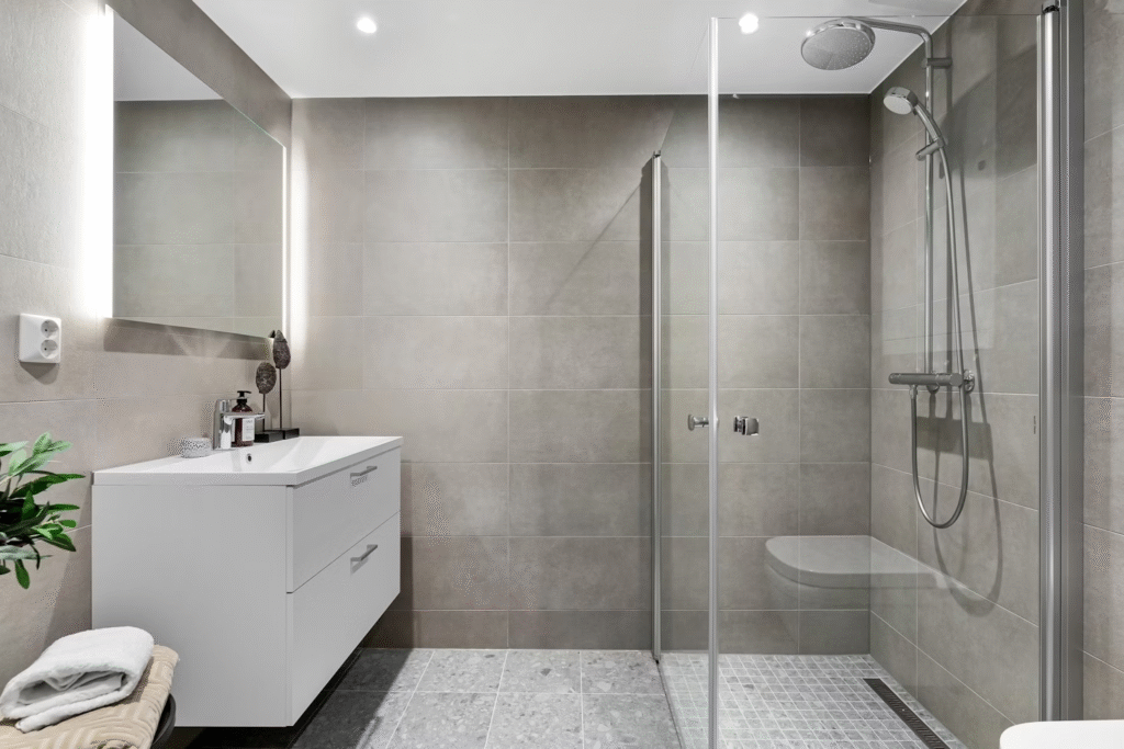 spacious modern bathroom with white sink and a walk-in shower