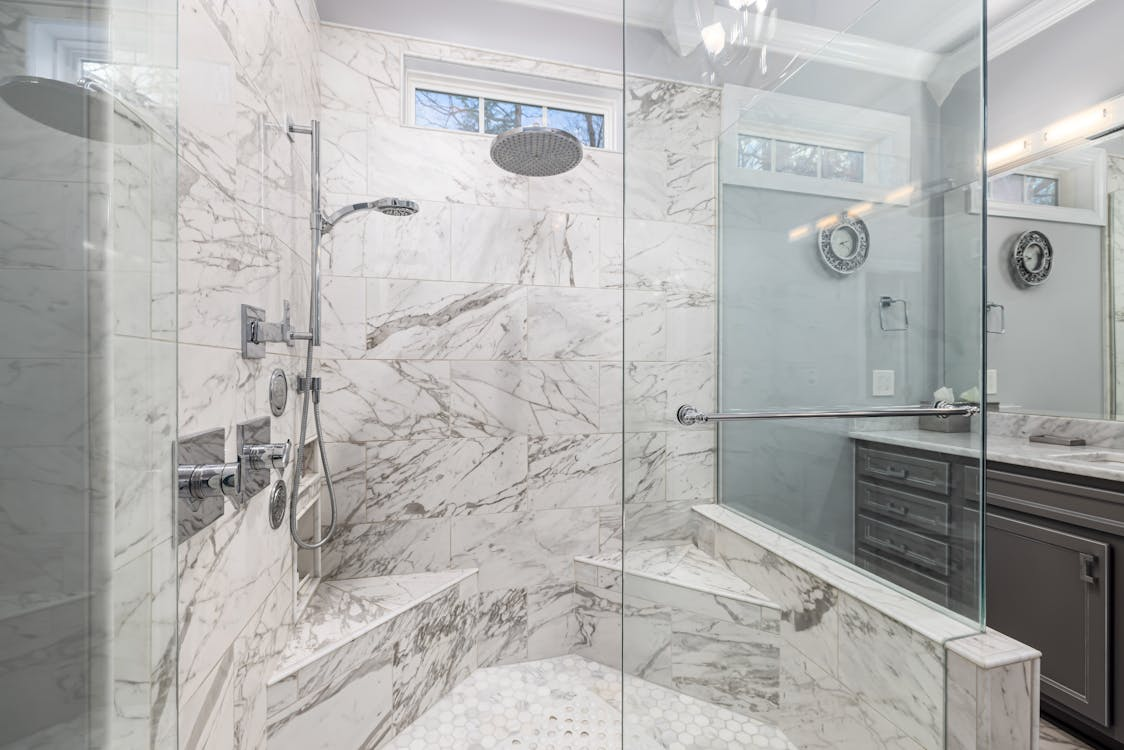 modern shower with glass doors and space to sit inside