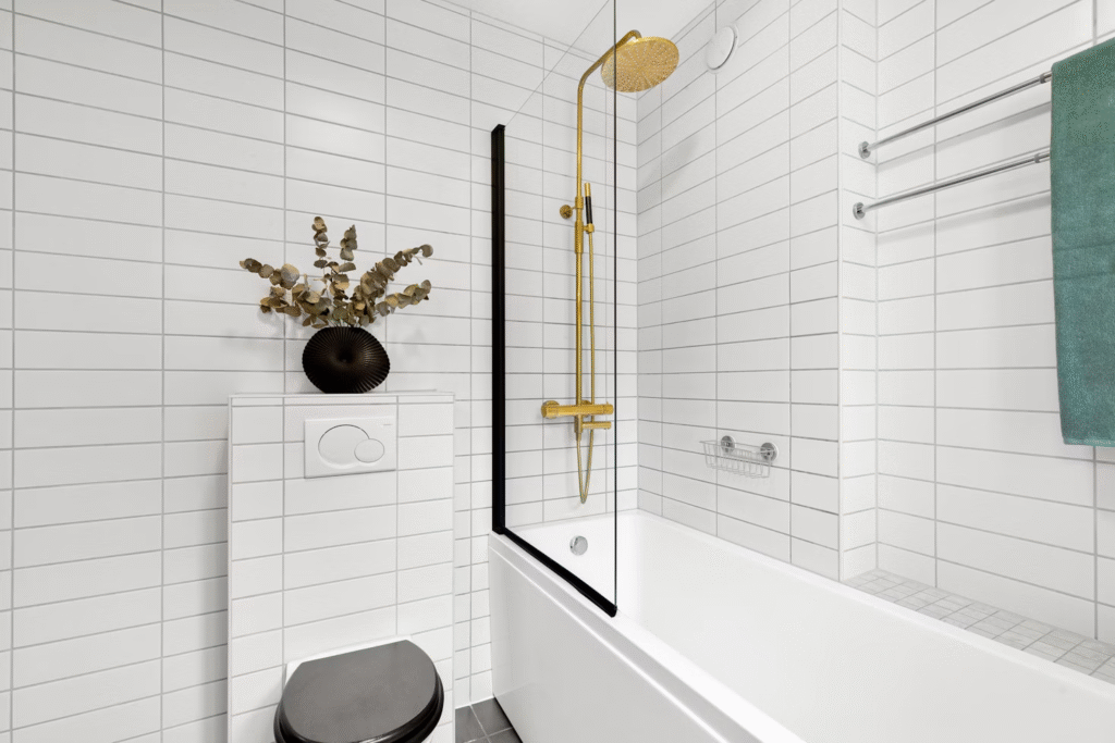 close up of a toilet with an attached bathtub to the wall and a shower