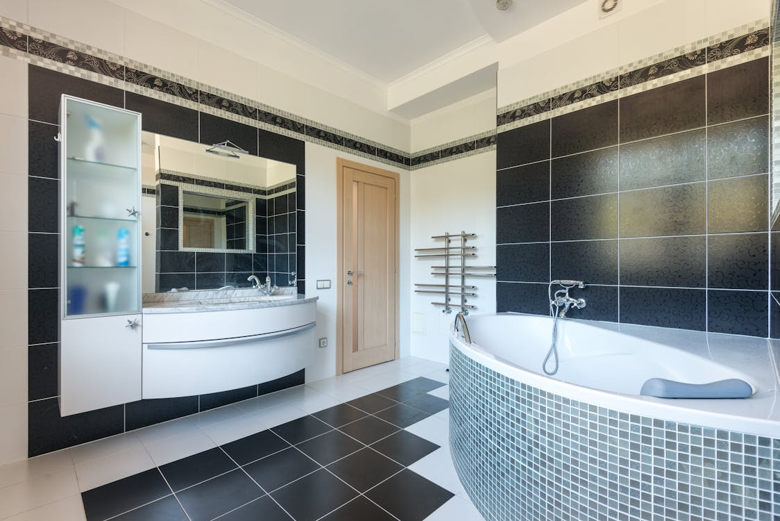 A contemporary bathroom featuring a vertical storage cabinet beside the vanity.