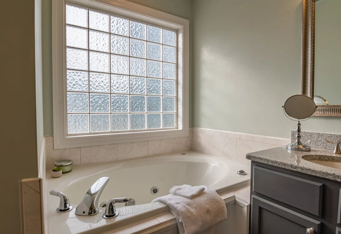 close up of a ceramic bathtub next to a window