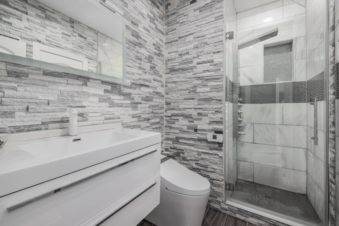 A modern bathroom with a walk-in shower enclosed by a clear glass door.