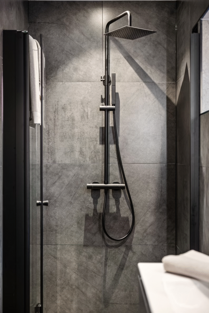 close up of shower attached to a wall inside a walk-in shower with back interior