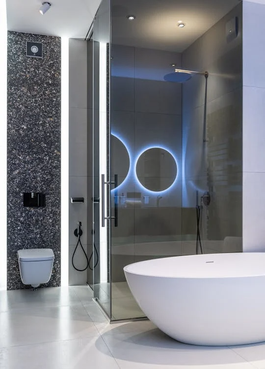 Interior of a modern, spacious bathroom with bright lighting, floating vanity, and large mirror