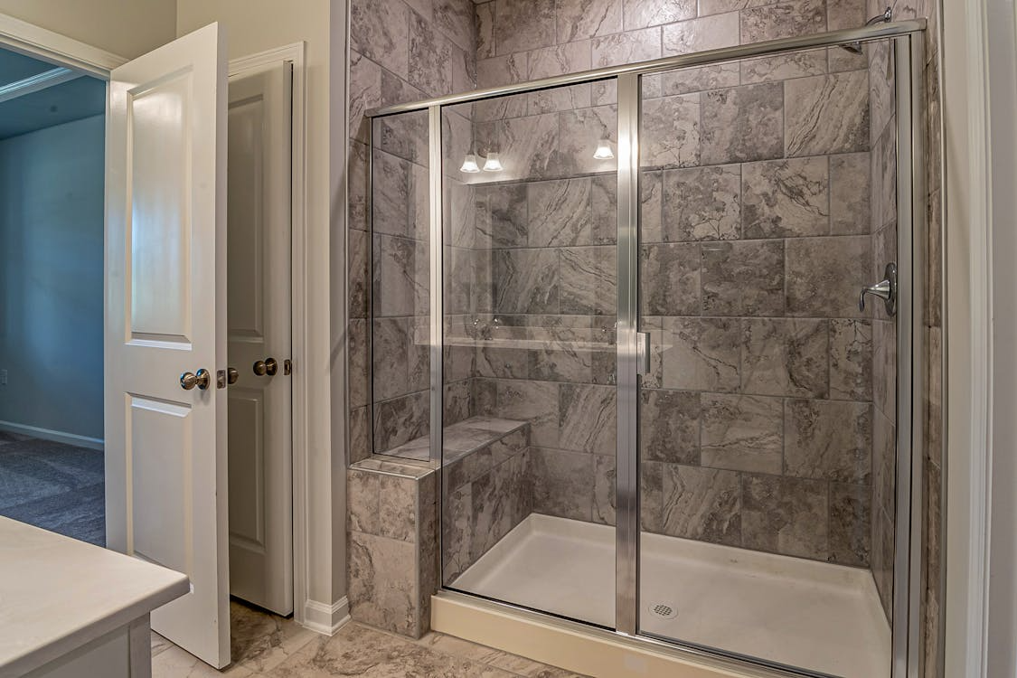 A bathroom featuring a walk-in shower with a built-in seat.