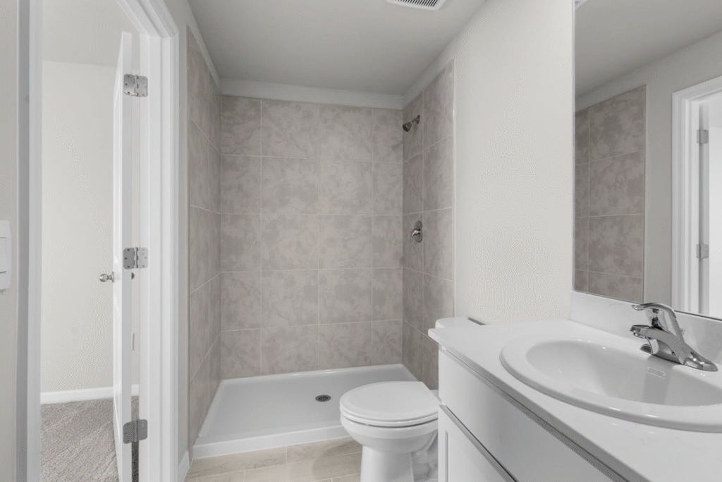 Modern minimalist bathroom with white fixtures, walk-in layout, and clean design