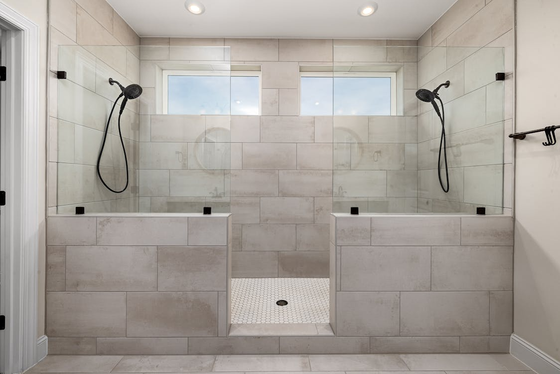 Bathroom with tiled walls featuring a walk-in bathtub and shower combination