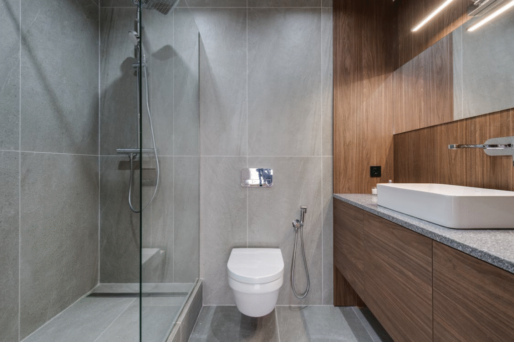 Bathroom interior featuring a modern walk-in shower with glass partition and tiled walls