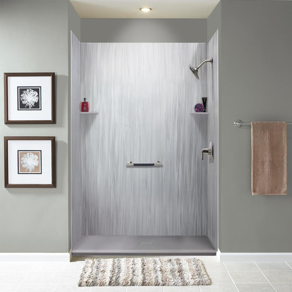 Modern bathroom shower stall in a bathroom with a mat, pictures on the wall, and a towel hanger.